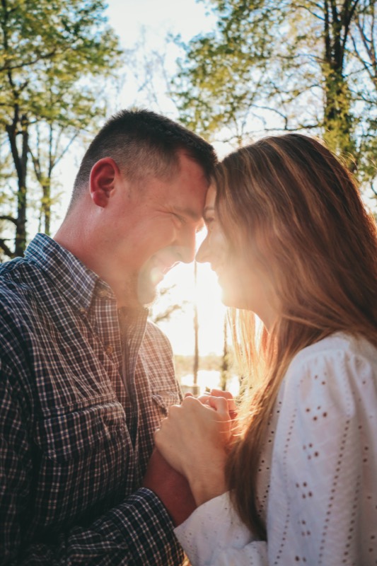 Engaged couple forehead to forehead in golden light