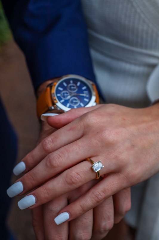 Her hand with the new ring resting on his
